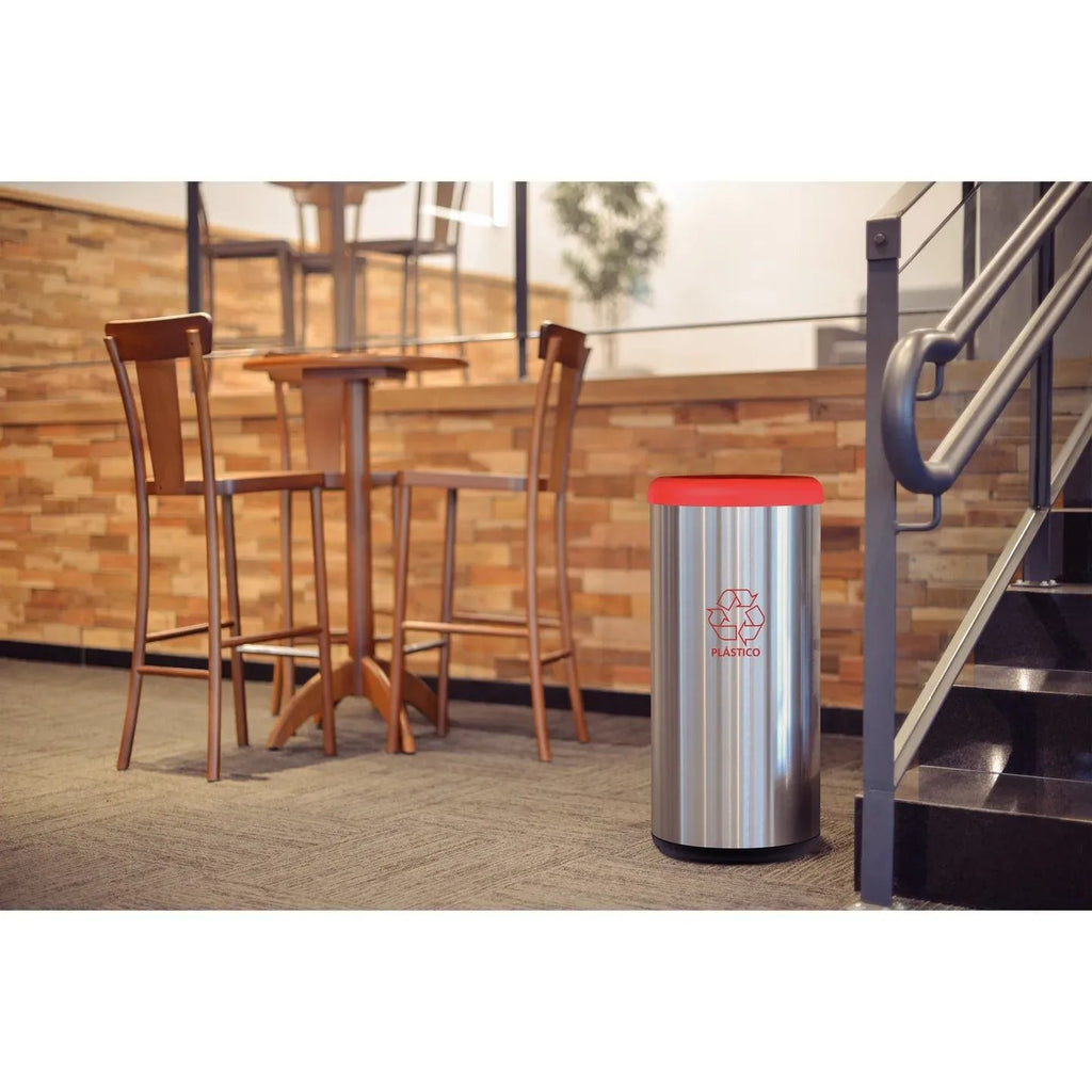 Bote de basura cilíndrico de acero inoxidable con tapa roja y símbolo de reciclaje para plástico, en lobby comercial