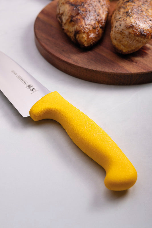 Cuchillo con mango amarillo y hoja de acero inoxidable junto a tabla de madera con papas asadas