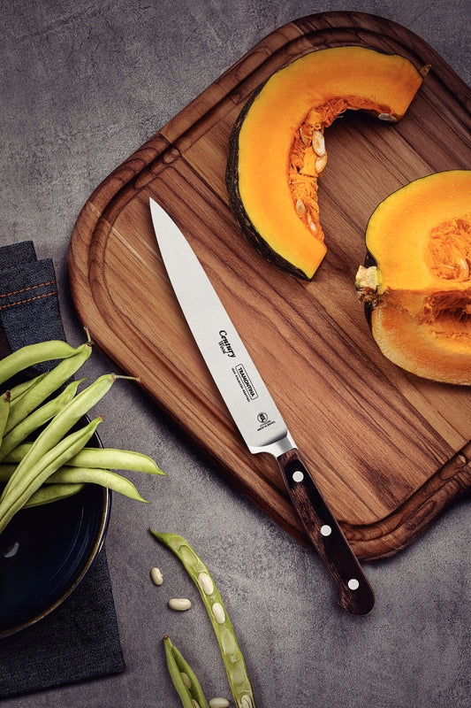 Cuchillo Tramontina Century con mango de madera sobre tabla de cortar, junto a rodajas de calabaza y vainitas verdes